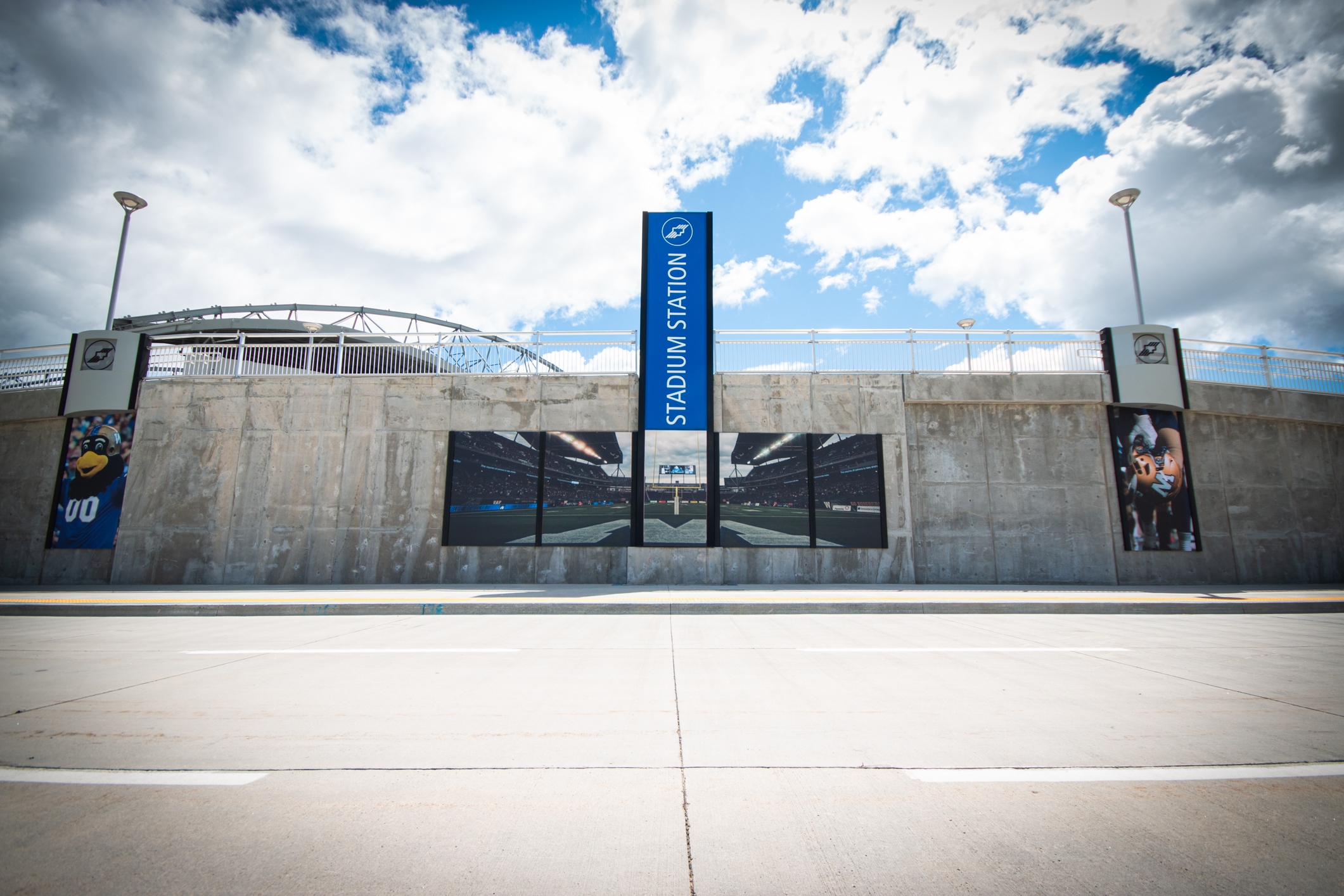 A trio of images taken during a Winnipeg Blue Bomber football game are displayed on a concrete wall